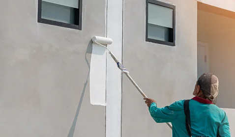 professional painter working in the exterior of a building
