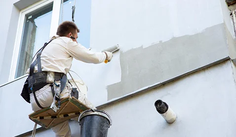professional painter working in in the exterior of a house